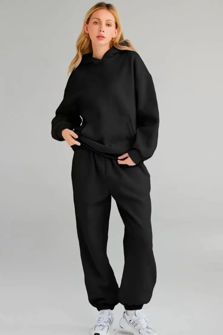 Person wearing a black tracksuit on a gray background