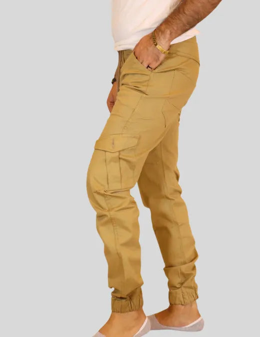 Person wearing beige cargo pants on a plain background