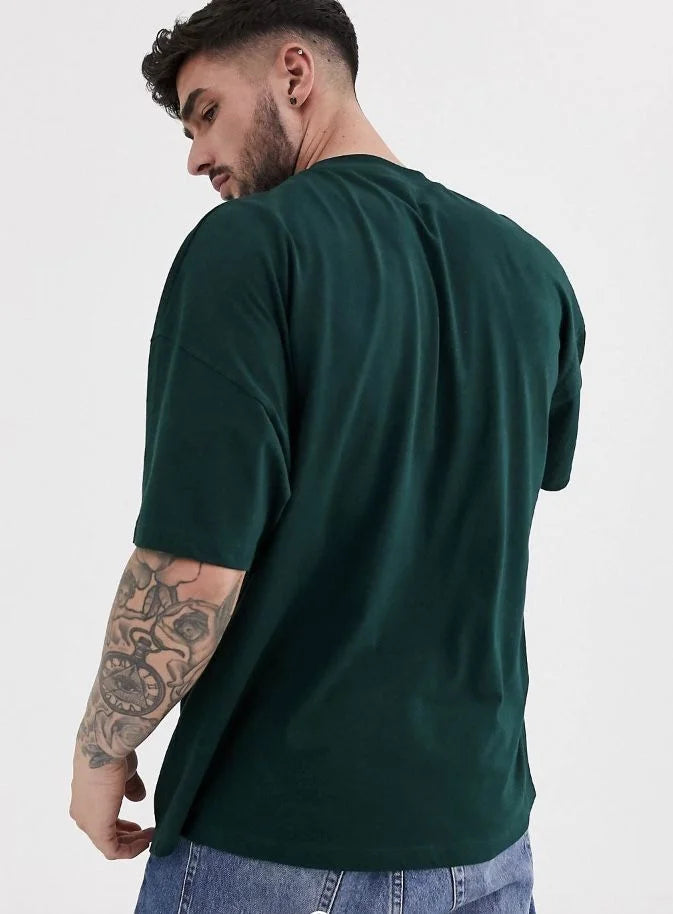 Man wearing a green t-shirt and jeans on a white background