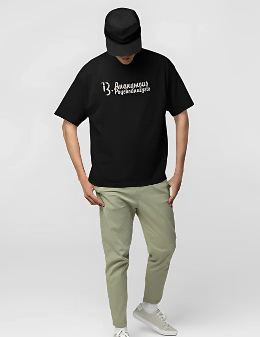 Person wearing a black t-shirt with text and light green pants on a white background