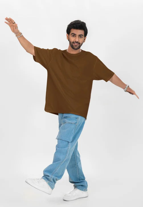 Man wearing a brown t-shirt and blue jeans on a white background