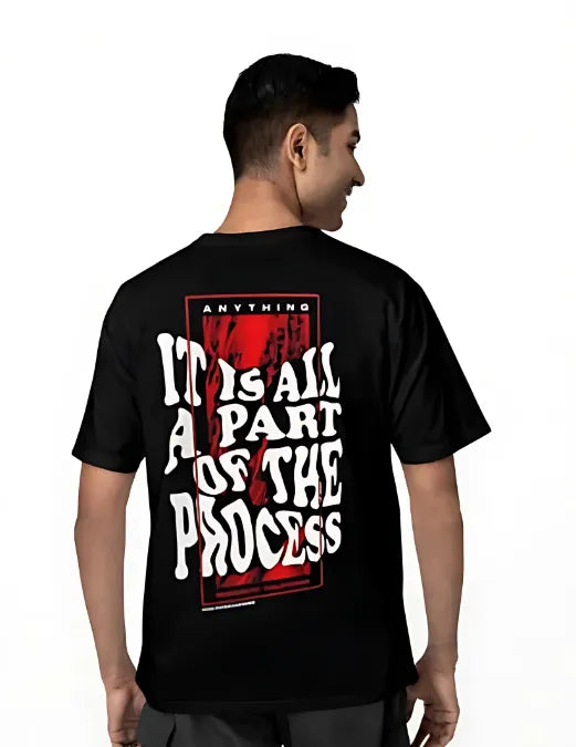 Person wearing a black t-shirt with text on the back, standing against a white background