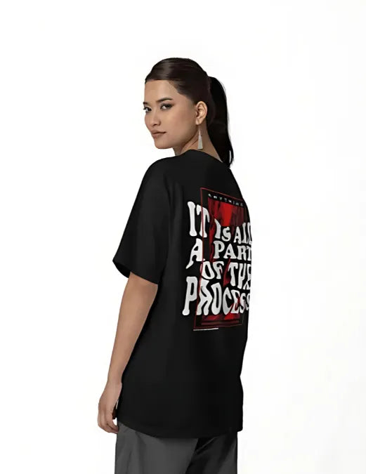 Person wearing a black t-shirt with text on the back, standing against a white background