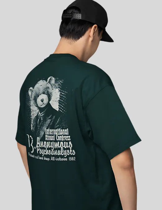 Person wearing a dark green t-shirt with a graphic design on the back, standing against a plain background.