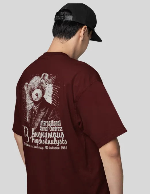 Person wearing a maroon t-shirt with a graphic design on the back, standing against a plain background.