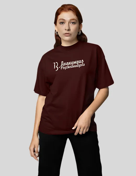 Person wearing a maroon t-shirt with text on a plain background