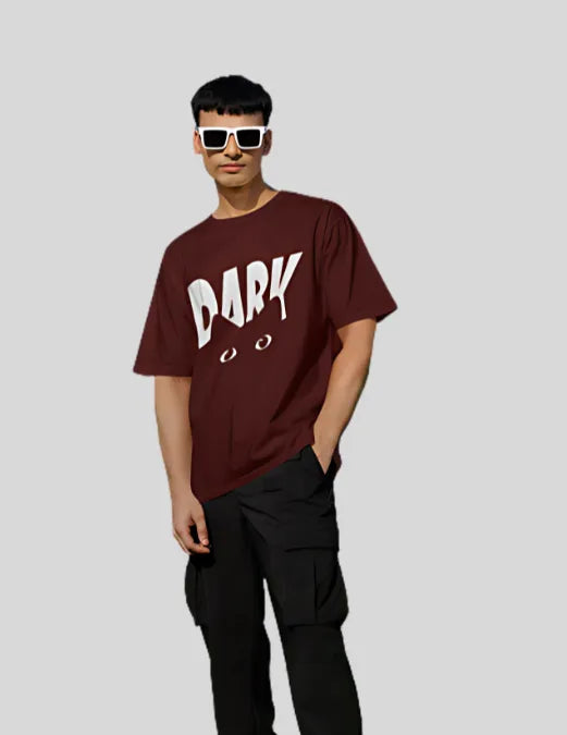 Person wearing a maroon t-shirt with 'DARK' printed on it against a plain background