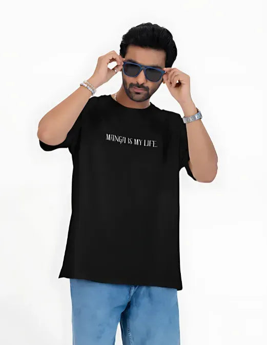 Man wearing a black t-shirt with text and blue pants on a white background