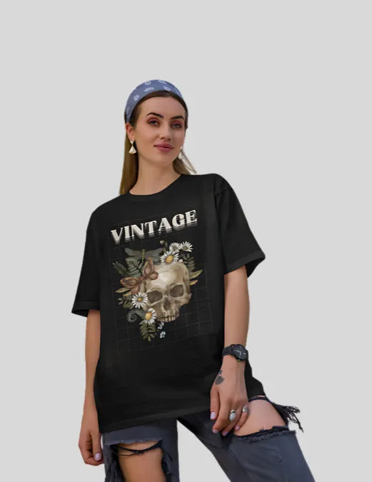 Woman wearing a black 'Vintage' t-shirt with a skull design on a plain background