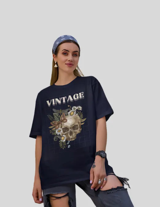 Woman wearing a blue'Vintage' t-shirt with a skull design on a plain background