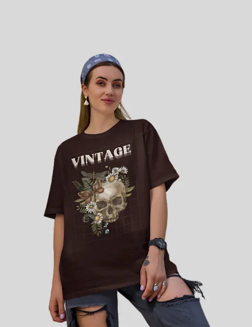Woman wearing a brown 'Vintage' t-shirt with a skull design on a plain background