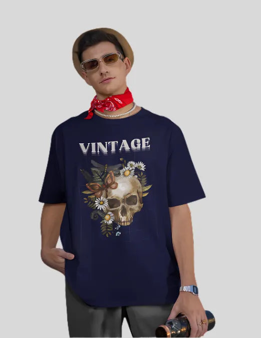 Person wearing a navy blue t-shirt with a skull and floral design, standing against a plain background.