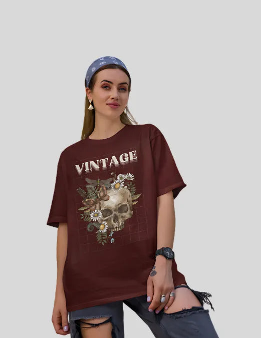 Woman wearing a maroon 'Vintage' t-shirt with a skull and floral design on a plain background